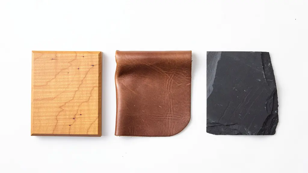 Wide shot of premium Canadian materials arranged on minimal white surface showing wood grain, leather texture, and stone patterns