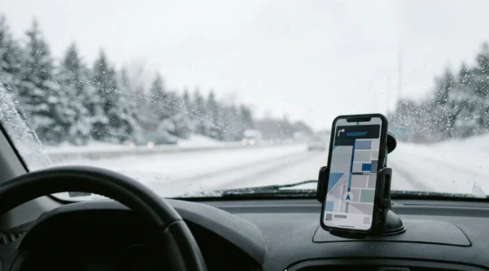 Canadian commuter's car dashboard during winter commute with smartphone navigation app interface visible